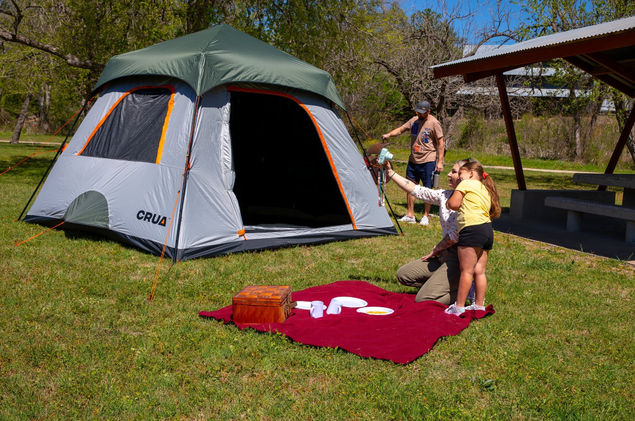 Crua Noir 6 Cabin Tent in a lifestyle setting with a family cooking, relaxing, and enjoying their camping experience